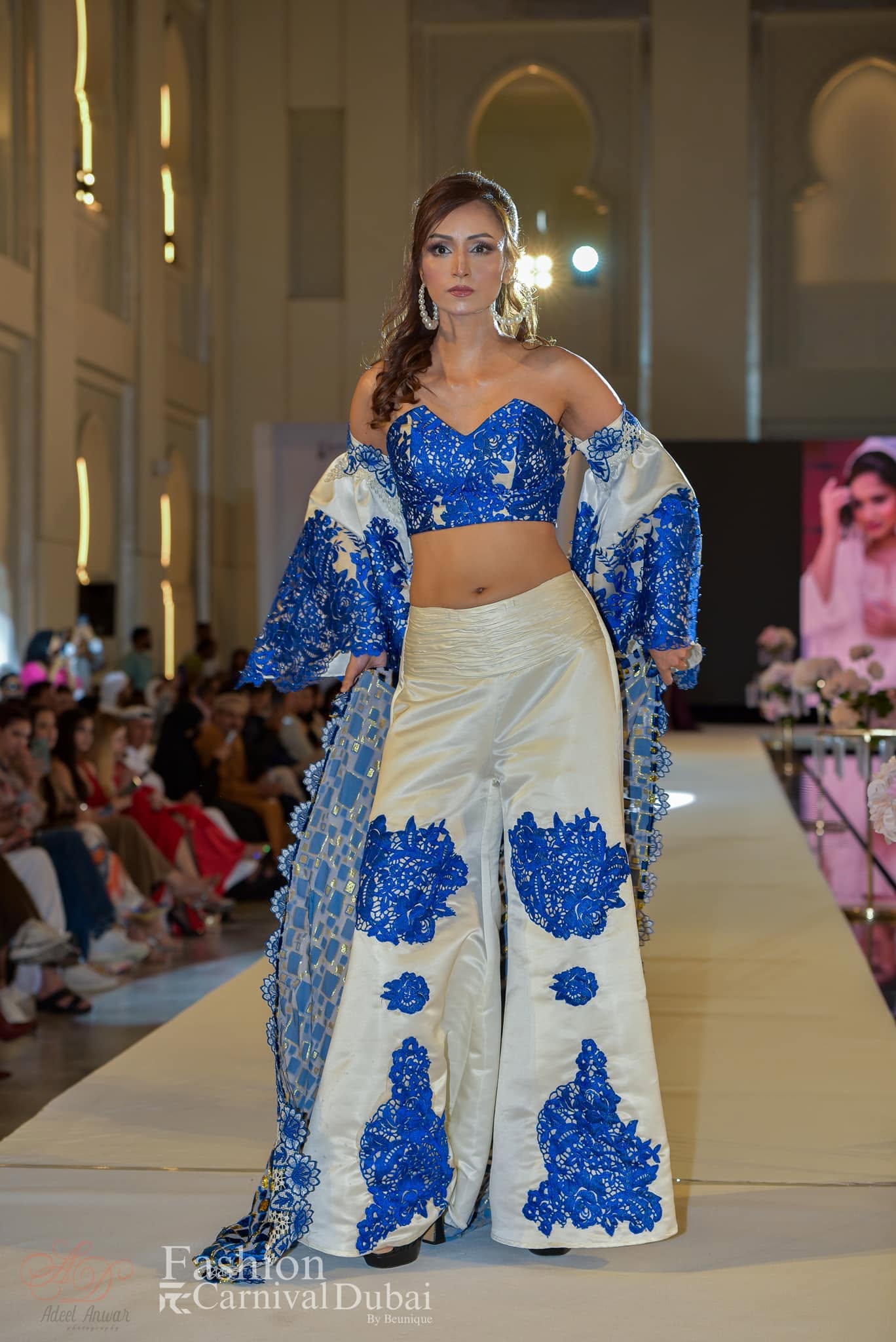 A blue and ivory floral ensemble with wide-leg trousers on the Fashion Carnival Dubai runway