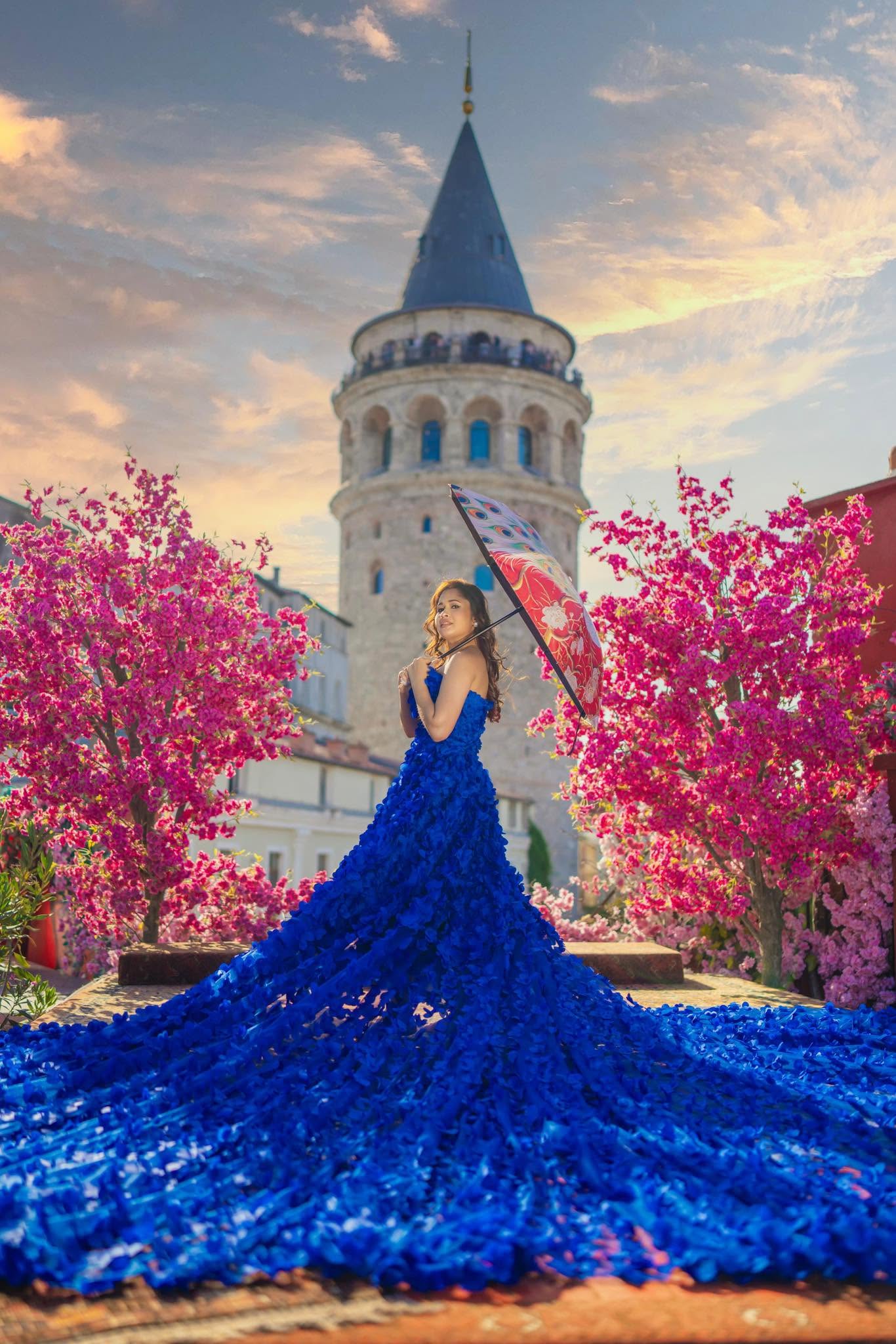 A royal blue gown with a sweeping textured train, photographed beside Galata Tower
